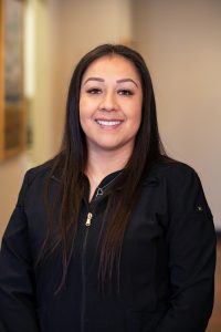 A woman in black shirt smiling for the camera.