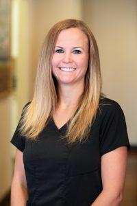 A woman with long blonde hair wearing black shirt.