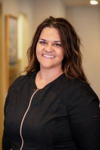 A woman in black jacket smiling for the camera.